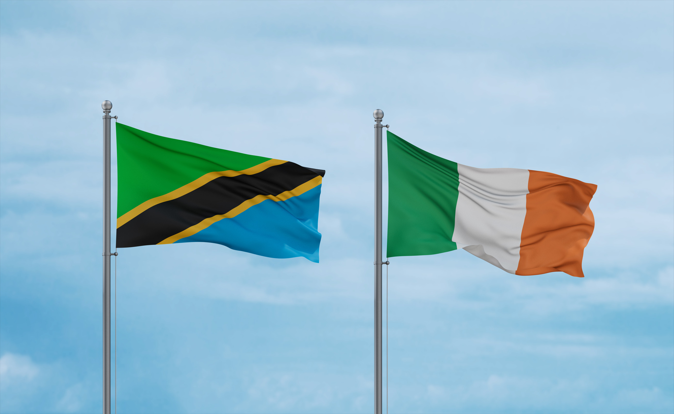 Cote Divoire And Tanzania Flags Waving Together In The Wind On Blue Cloudy