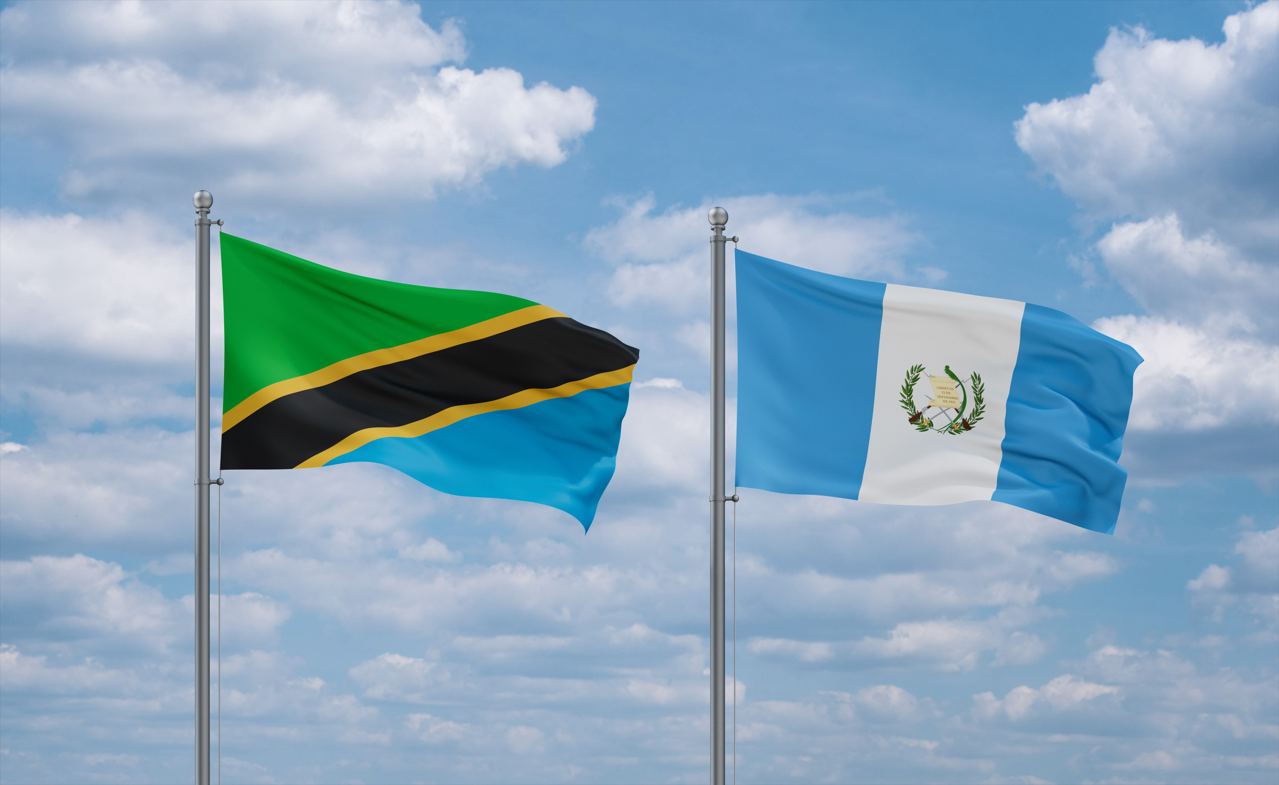 Guatemala And Tanzania Flags Waving Together On Blue Cloudy Sky