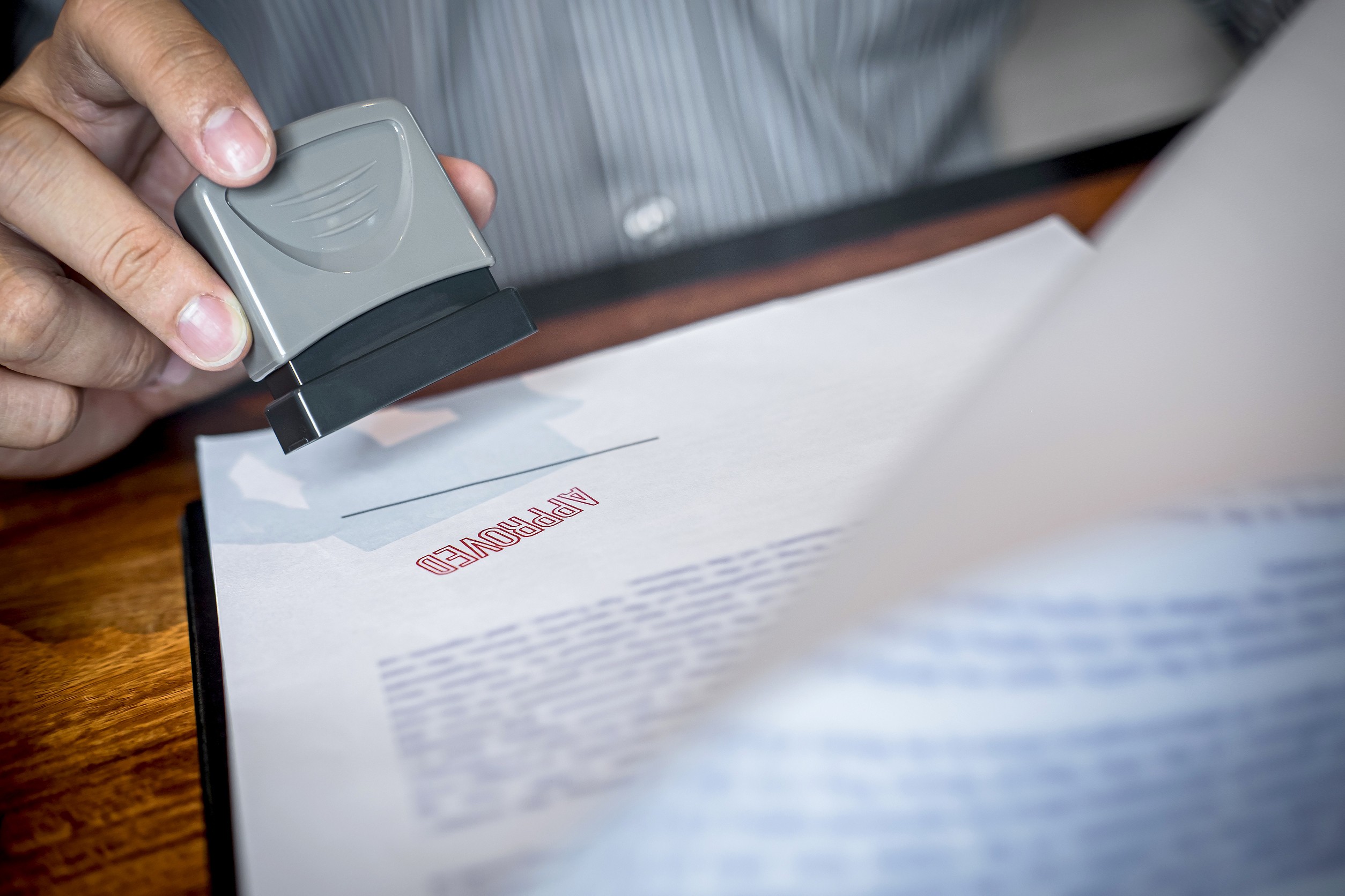 Hands Of Businessman Stamp On Paper Document To Approve Business Investment Contract