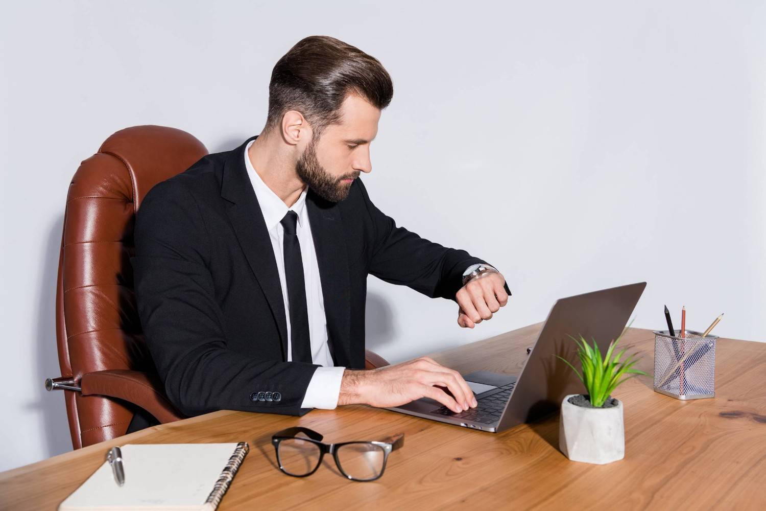 Person Checking Time While Working On His Laptop