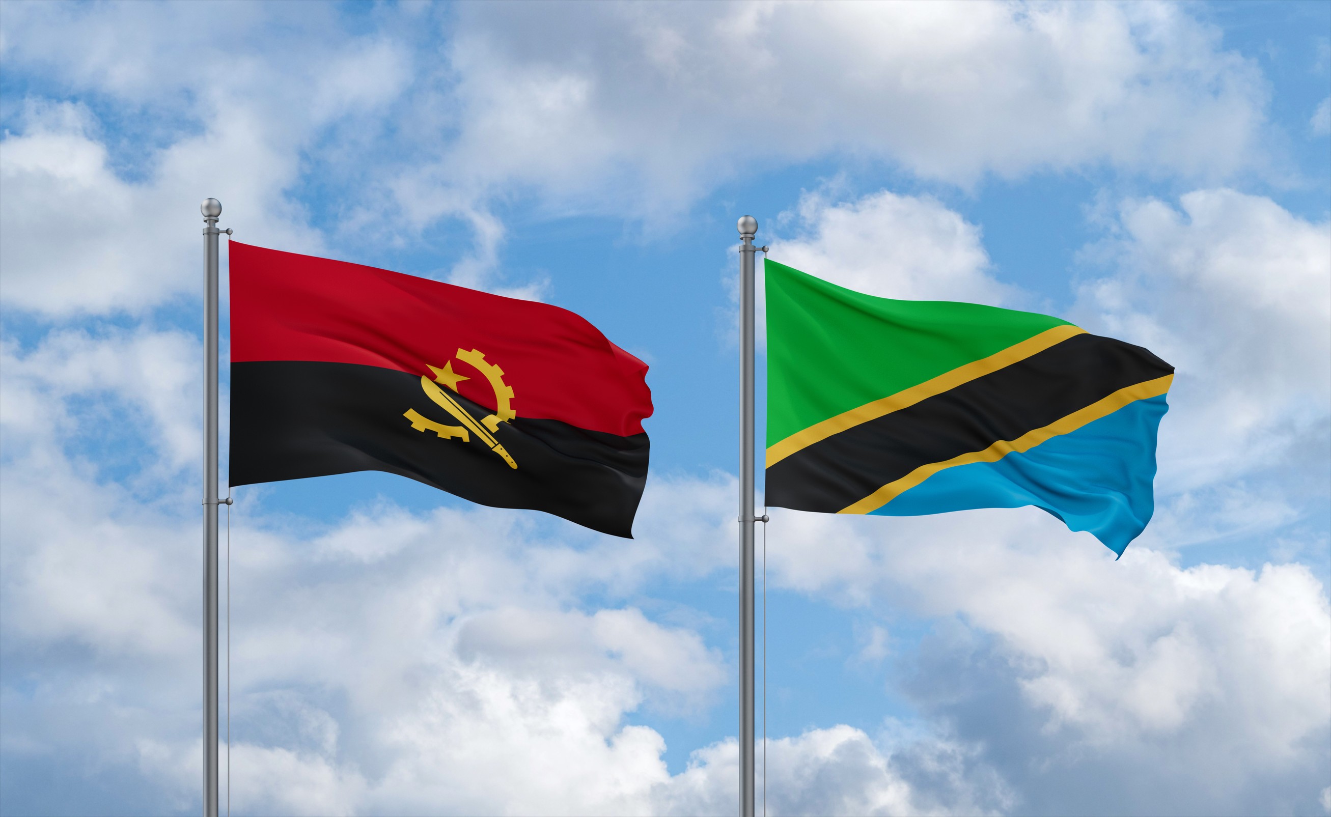 Tanzania And Angola Flags Waving Together In The Wind
