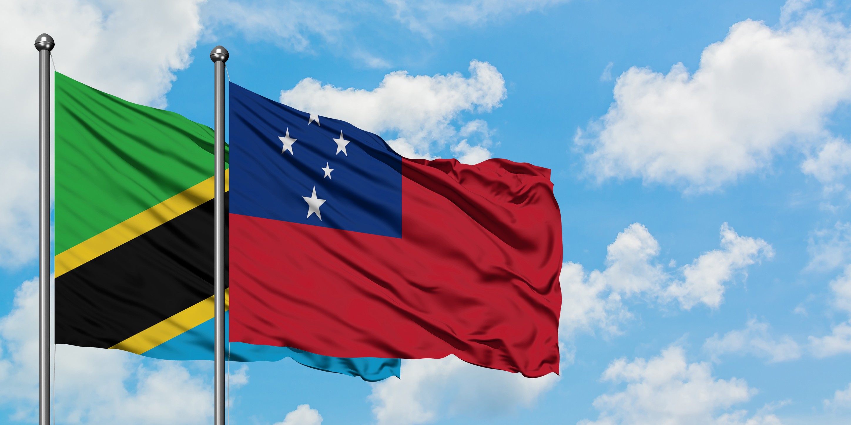 Tanzania And Samoa Flag Waving In The Wind Against White Cloudy